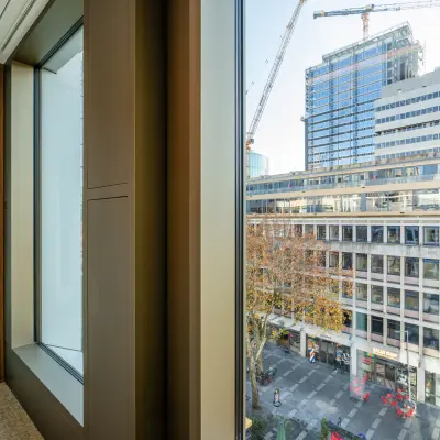 View from the interior of an office space in Stadhuisplein 9-23, Rotterdam Center, overlooking urban buildings and a construction site, ideal for office space rental.