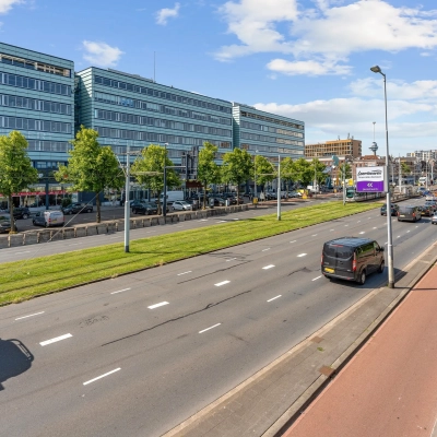 Street view of Vasteland 42-110 in Rotterdam Center showing a modern office building with cars passing by, ideal for those looking to rent office space.