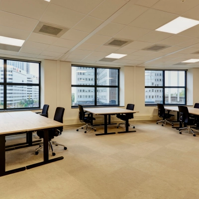 Bright office space at Weena 335, Rotterdam Center, featuring large windows and modern furniture. Ideal for those looking to rent office space with multiple desks and chairs.