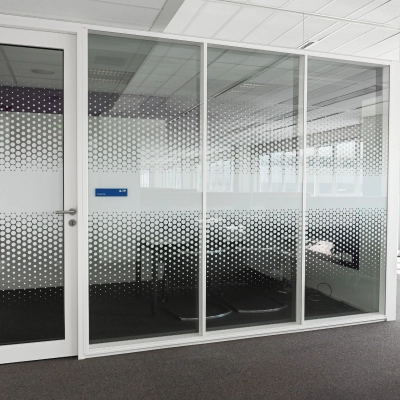 Modern office space to rent at Weena 70, Rotterdam Center, featuring a glass-walled meeting room with geometric patterns offering natural light.
