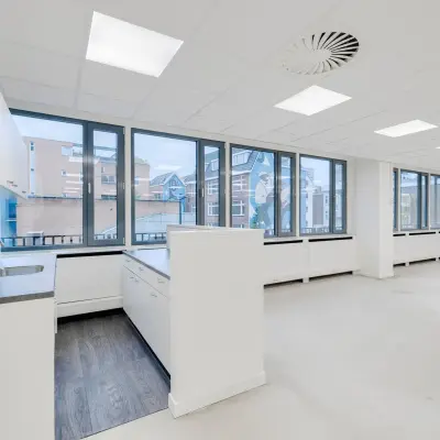 Modern office space for rent at Westblaak 109, Rotterdam Center, featuring large windows and a kitchenette with a sink.