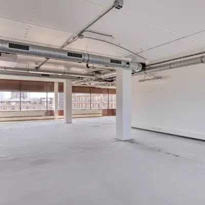 Spacious office to rent at Kratonkade 7 - 27 in Rotterdam Delfshaven, featuring an open floor plan with large windows.