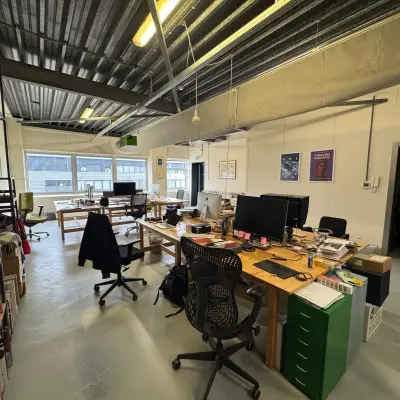 Spacious office at Van Helmontstraat 17-23 in Rotterdam Delfshaven, featuring multiple desks with office equipment and chairs, perfect for office space rental.