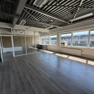 Spacious and sunlit office space with large windows, available for rental in Rotterdam Delfshaven at Van Helmontstraat. The area features natural light and potential for flexible workspace configurations.