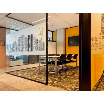 Modern furnished office space for rent at Wilhelminakade 173, Rotterdam Kop van Zuid, featuring a glass-enclosed conference room with a city skyline design and a large table with chairs.