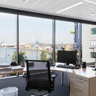 Bright office space at Waalhaven O.z. 83, Rotterdam Waalhaven, featuring a modern desk setup with a scenic harbor view, ideal for office space rental.