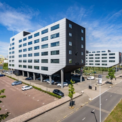 Office building exterior at Waalhaven O.z. 83 in Rotterdam Waalhaven with ample parking space, ideal for office space rental.