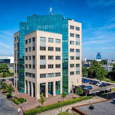 Modern office building exterior at Overschieseweg 304-332, Schiedam. The multi-story structure features large glass windows and a well-maintained surrounding area, ideal for office space rental.