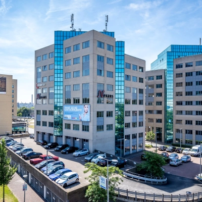Exterior view of modern office buildings at Overschieseweg 304-332 in Schiedam, featuring large glass windows and ample parking. Ideal for businesses seeking office space rental.