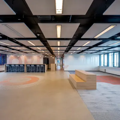 Spacious, modern office space at Schiphol Airport with sleek design elements and ample seating, perfect for rental opportunities.