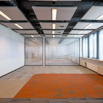 Spacious office for rent at Schiphol Airport with unique ceiling design and vibrant flooring, ideal for office space rental.