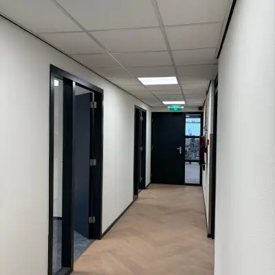 Hallway in an office located at Fischerpad 106, Sittard with wood flooring and closed office doors, available for office space rental.