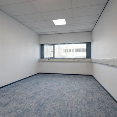 Unfurnished office space available for rent at Fischerpad 106, Sittard, featuring a spacious window and modern flooring. Ideal for setting up a personalized workspace.