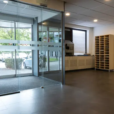 Bright office lobby at Curieweg 9, Spijkenisse, featuring a glass entrance and storage units. Ideal for office space rental with convenient access.