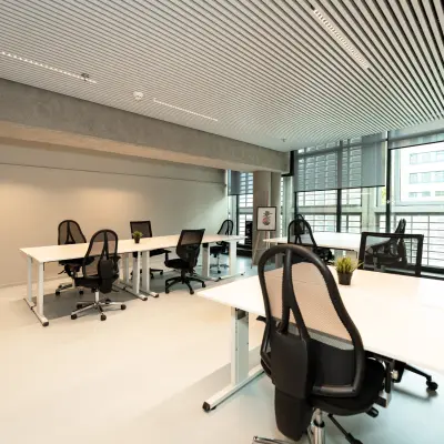 Office space for rent at Waldopstraat 5, The Hague Center featuring modern workstations with ergonomic chairs and computers.