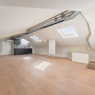 Spacious office space rental at Zeestraat 100, The Hague Center, featuring wooden flooring, skylights, and a kitchenette.