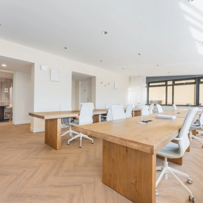 Bright office space to rent at Zeestraat 100, The Hague Center, featuring wooden desks and white chairs in a spacious layout for office space rental.