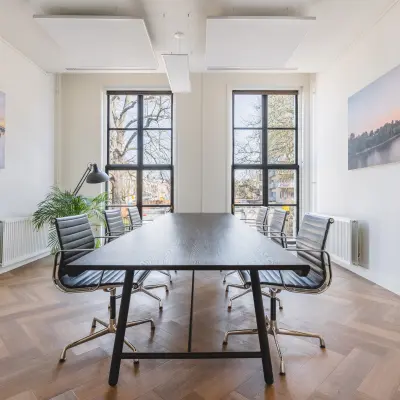Bright office at Zeestraat 100, The Hague Center, featuring large windows, a sleek table, and stylish chairs. Perfect spot for your next office space rental.