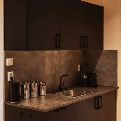 Compact pantry at Zeestraat 100, The Hague Center, ideal for office space rental, featuring a small sink, coffee machine, and storage.