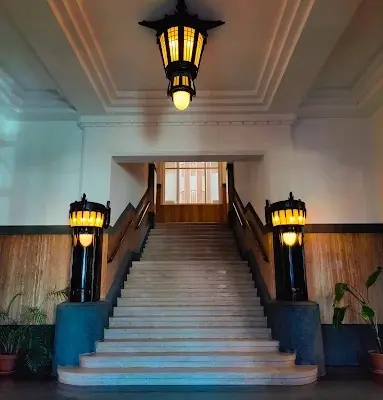 Interior photo of a well-lit entrance with a grand staircase and wooden accents, ideal for rent office space in The Hague.