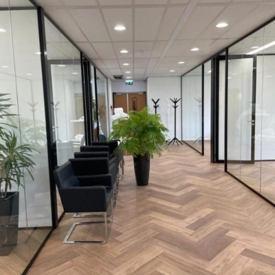 Modern corridor with glass walls and chairs on Johan de Wittlaan 3-7, ideal for office space rental in The Hague Statenkwartier.