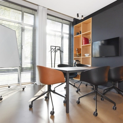 Bright office to rent at President Kennedylaan 19, The Hague Statenkwartier, featuring modern furnishings, a large window for natural light, and a sleek table with chairs ideal for meetings.