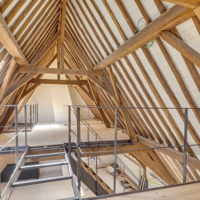 Interior view of an unfurnished attic office space with wooden beams at Brigittenstraat 22 in Utrecht Center. Ideal for office space rental opportunities.