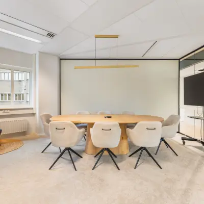 Bright conference room with a large oval table and modern chairs at Leidseveer 2-10. Ideal office space rental located in the heart of Utrecht Central Station.