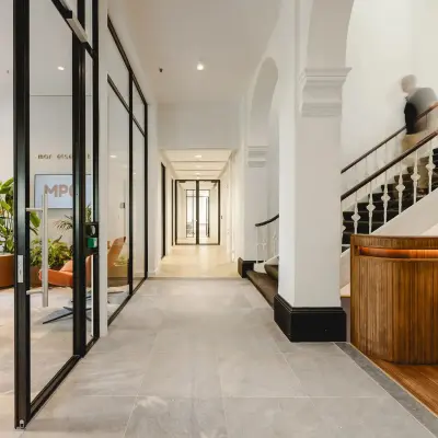 Spacious office entrance with modern design, featuring glass partitions and elegant wooden accents, located at Moreelsepark 1. Ideal office space rental opportunity in Utrecht Central Station.