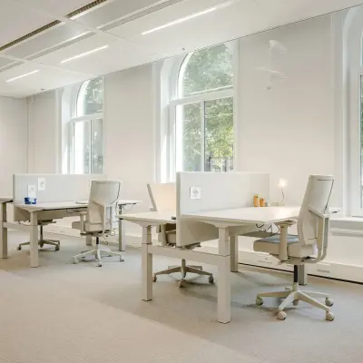 Bright office space at Moreelsepark 1, Utrecht Central Station, with large windows and desks for rent.