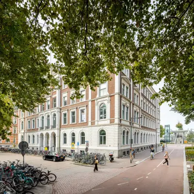Exterior view of office building at Moreelsepark 1, Utrecht Central Station, showing a potential office to rent amidst a bustling urban environment.