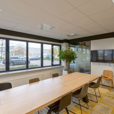 Modern office space at Atoomweg 400, Utrecht Lage Weide with a large table, chairs, and a TV, available for office space rental.