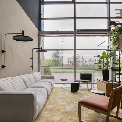 A modern, furnished office lounge space at Atoomweg 63, Utrecht Lage Weide, featuring comfortable seating, stylish decor, and large windows providing natural light. Ideal for rent office space seekers.