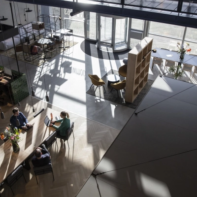 A modern, spacious office to rent at Atoomweg 63, Utrecht Lage Weide, featuring people collaborating at a large table in a naturally lit open floorplan.