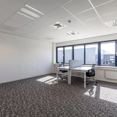 Bright office space with carpeted flooring and two desks, ideal for office space rental at Reactorweg 301, Utrecht Lage Weide.