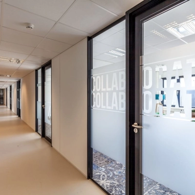 A hallway in an office space at Reactorweg 301, Utrecht Lage Weide, featuring glass doors labeled 'Collaborate'. An ideal office space rental opportunity.