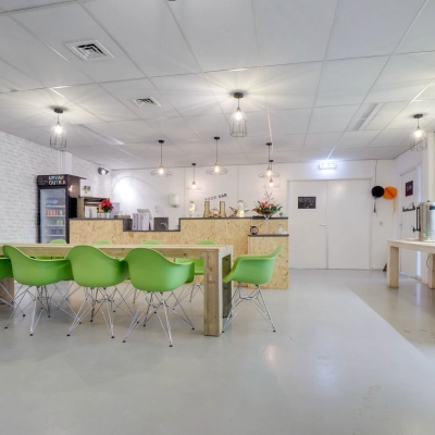 Modern office break area at Zonnebaan 18, Utrecht Lage Weide, with green chairs and a communal table. Ideal office space rental option.