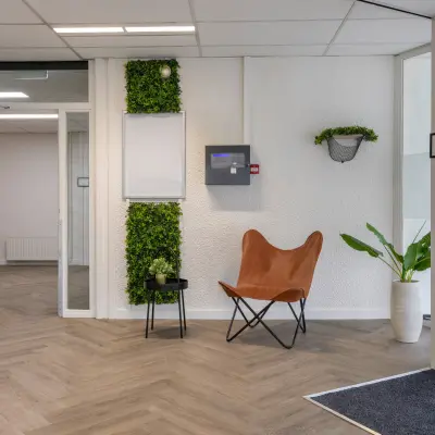 Modern office entrance at Zonnebaan 18, Utrecht Lage Weide, featuring chic seating, greenery, and sleek flooring, ideal for office space rental.