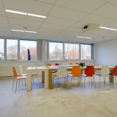 Bright office to rent in Utrecht Lage Weide at Zonnebaan 18, featuring large windows and a spacious table with colorful chairs, ideal for meetings.