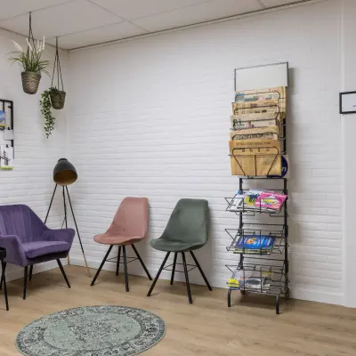 Cozy office waiting area with colorful chairs, a small table, and magazine rack at Zonnebaan 18, ideal for rent office space in Utrecht Lage Weide.