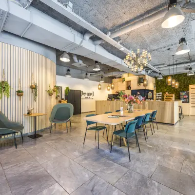 Modern office space available for rent at Goeman Borgesiuslaan 77, Utrecht North, featuring stylish seating areas and a large communal table set against a backdrop of contemporary interior design.