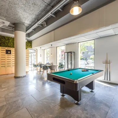 Bright and modern office space available for rent at Goeman Borgesiuslaan 77 in Utrecht North, featuring a pool table and seating area with large windows providing natural light.