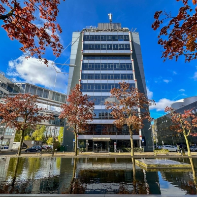 Exterior view of an office building at Daltonlaan 200 in Utrecht Rijnsweerd, featuring a clear sky and autumn trees. Ideal for businesses seeking office space rental.