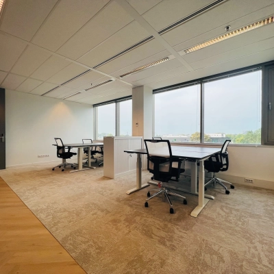 Furnished office space for rent in Utrecht South at Vliegend Hertlaan 15, featuring large windows and modern desks with chairs, ideal for workspace needs.