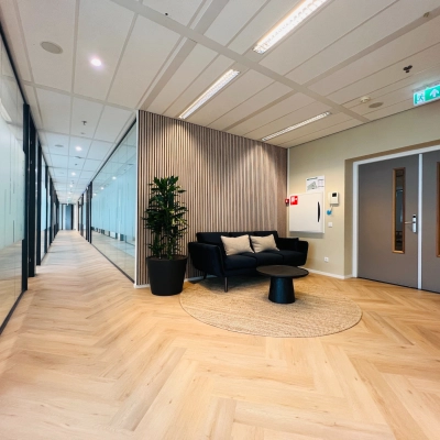 Modern office space in Utrecht South, ideal for rent, featuring a furnished corridor with cozy seating and stylish decor.