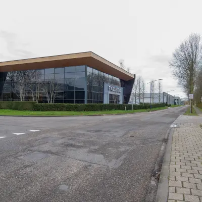 Exterior view of the office building at Gildestraat 13, Velp, featuring large glass windows and modern architecture, ideal for office space rental.