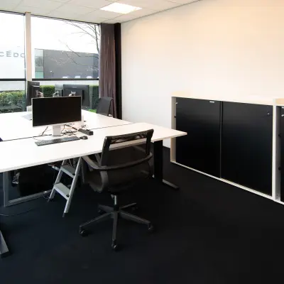 Modern office space at Gildestraat 13 in Velp with sleek desks, chairs, and a window view, ideal for rental.