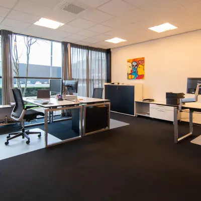 Modern office space rental at Gildestraat 13, Velp, featuring spacious desks and large windows with natural light.