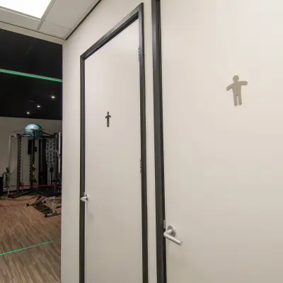 Office space at Gildestraat 13 in Velp, featuring a gym area with equipment visible near restroom doors. Ideal for an office space rental with fitness facilities.