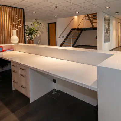 Modern reception area in an office to rent at Gildestraat 13, Velp, featuring a spacious desk with storage and contemporary design elements.